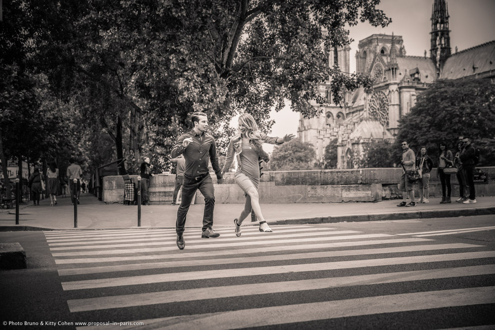 portrait jumping couple cross road in paris black and white