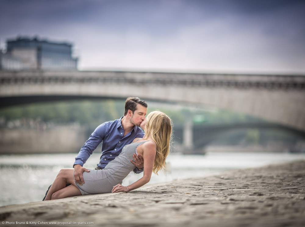 amazing portrait kissing couple in love sitting on seine banks in paris