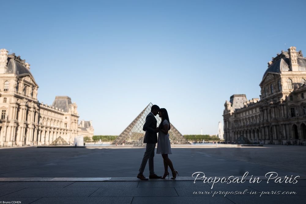 couple in silhouette cuddling in the morning in front of the Pyramide du Louvre