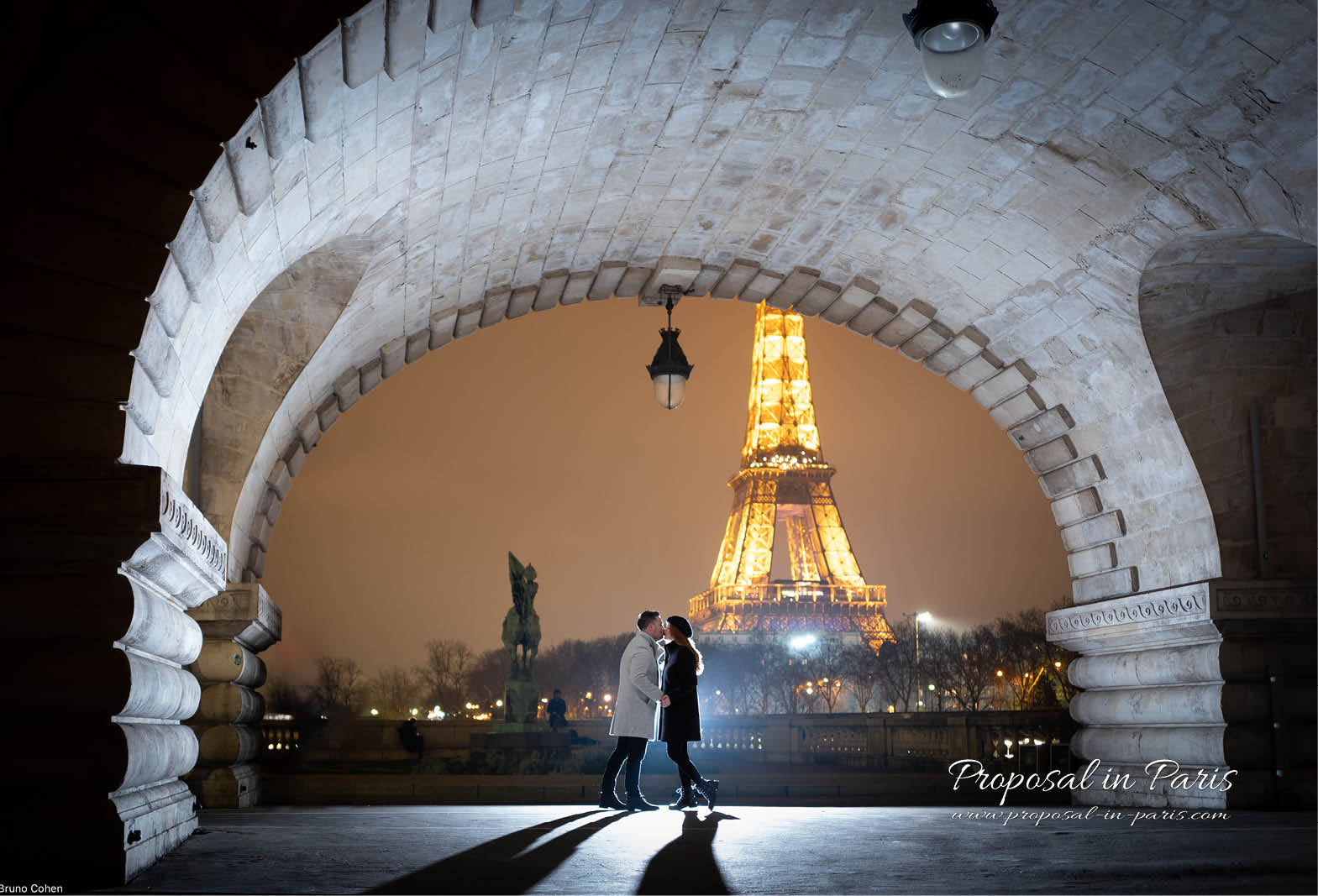 Couple kissing under the Bir Hakeim bridge in front of the Eiffel Tower